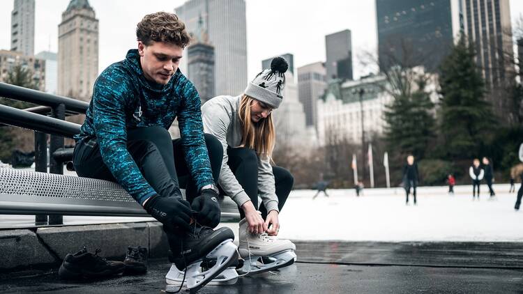 Skaters at The Wollman Rink with skyline in the background.