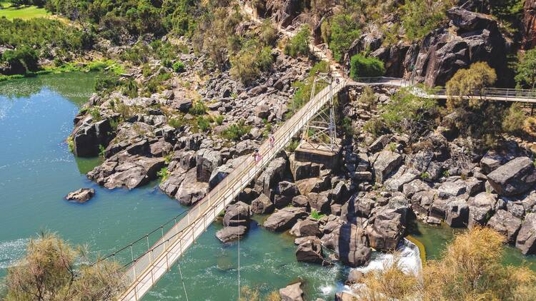 People cross Alexandra Suspension bridge at Cataract Gorge's First Basin.