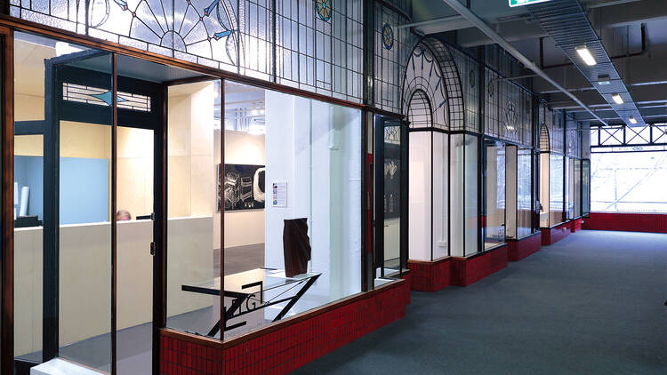 The exterior of gallery windows with art pieces inside. 