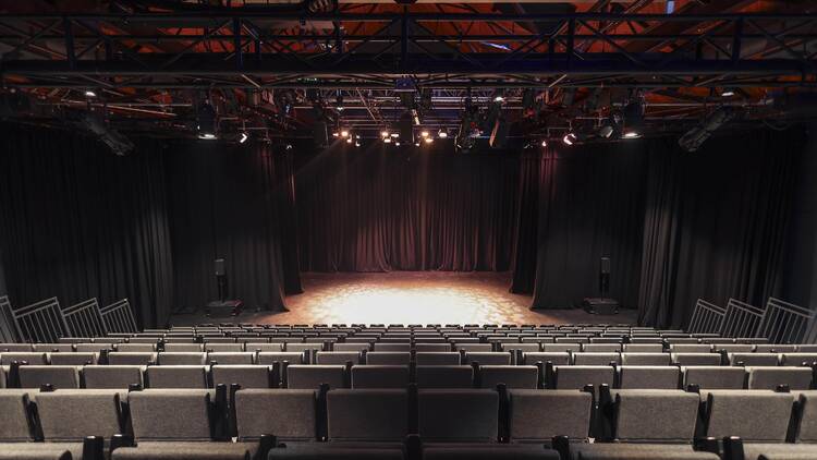 A theatre with rows of seats above a stage. 