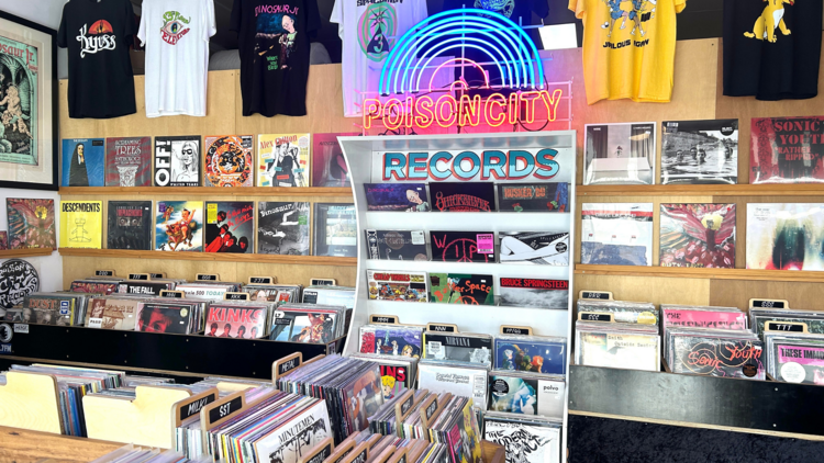 Warmly decorated interior of Poison City Records including a neon logo sign