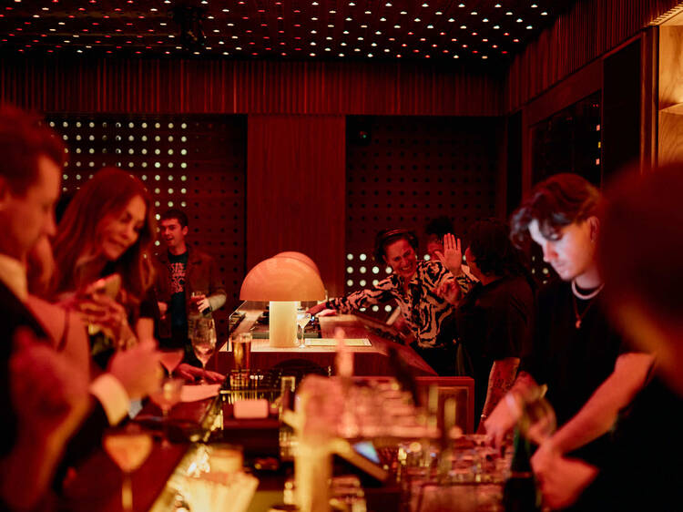 A busy bar with a DJ in the background. 