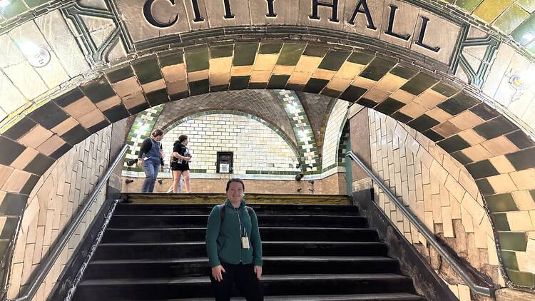 Standing on the city hall subway steps.