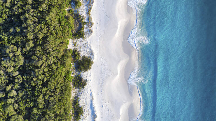 Aerial overlooking the white sands of Hyams Beach, Jervis Bay.