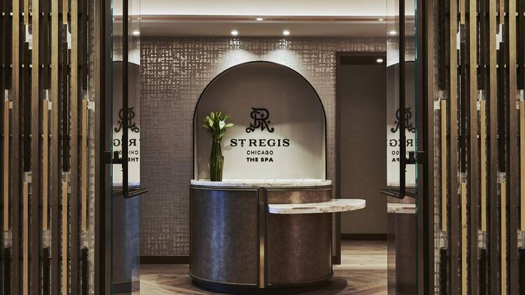 A doorway leading to a lobby area with a counter and the St. Regis logo