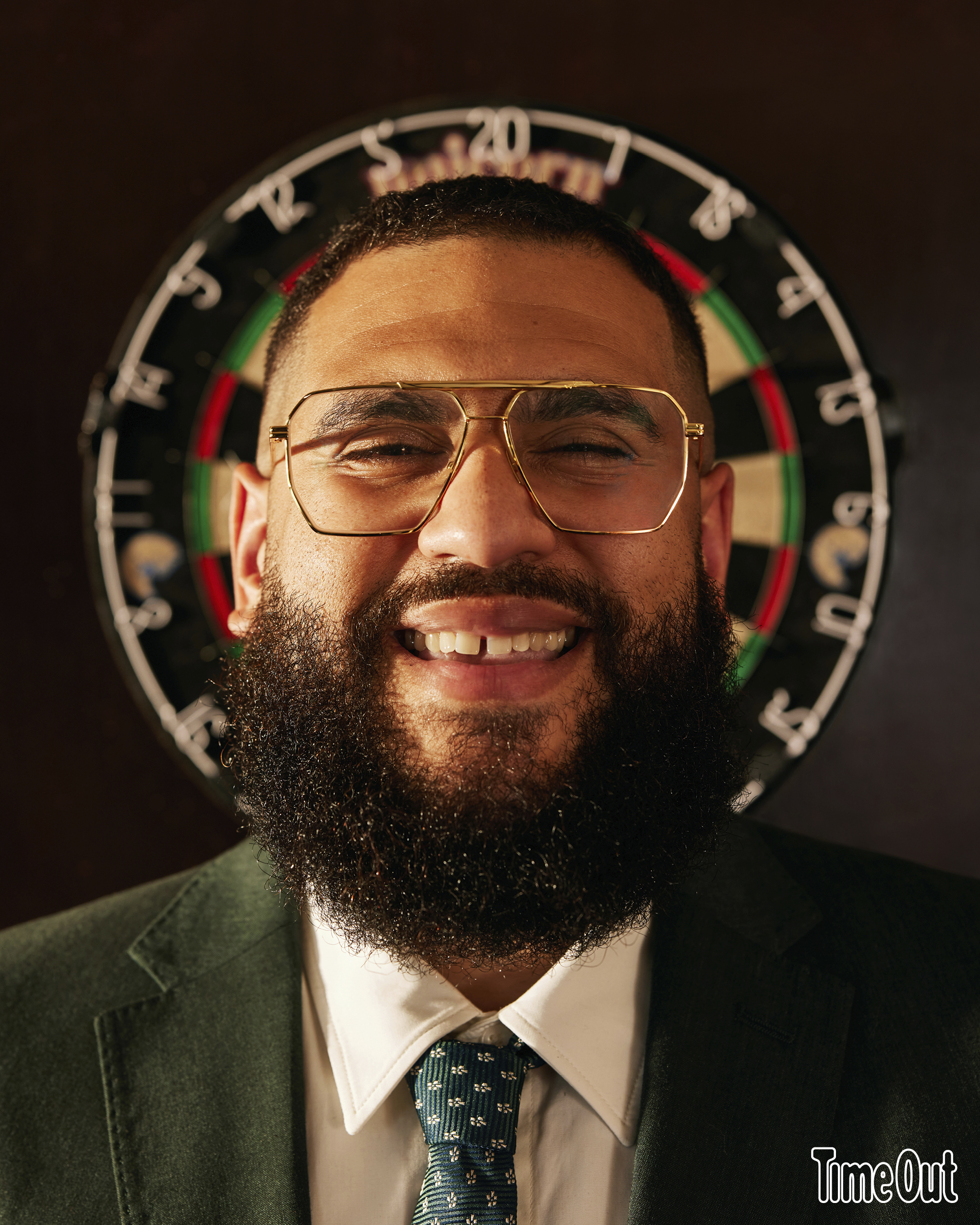 Jamali Maddix in front of a dart board