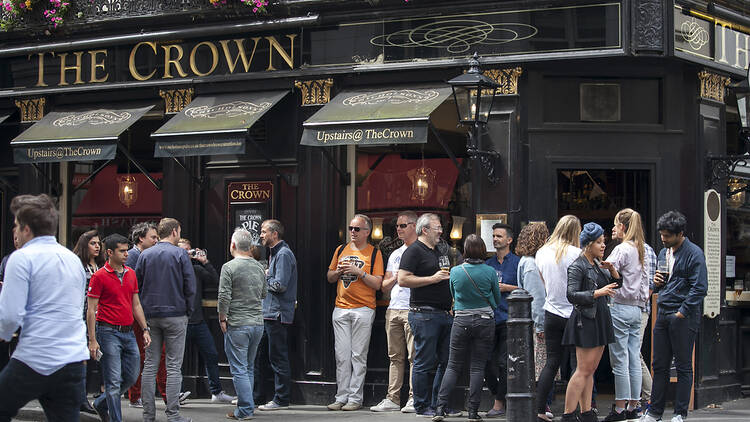 People drinking and smoking outside a pub in London