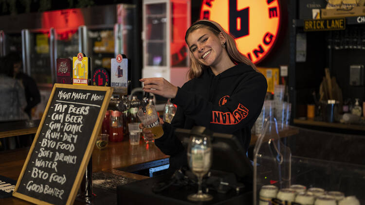 A person young woman pouring a beer at Brick Lane Brewing.