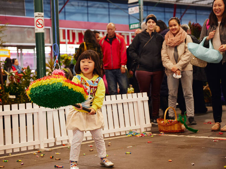 Preston Market Latin Day A child hitting a pinata.