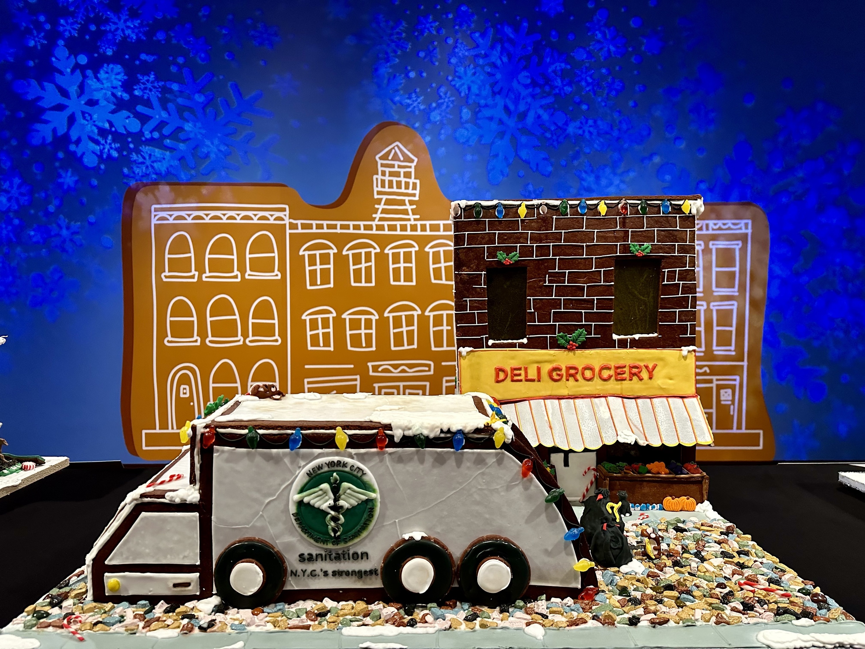 A gingerbread rendering of a bodega and a garbage truck.