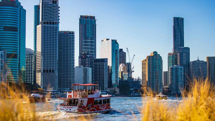 Boat sailing on water near city under clear blue sky