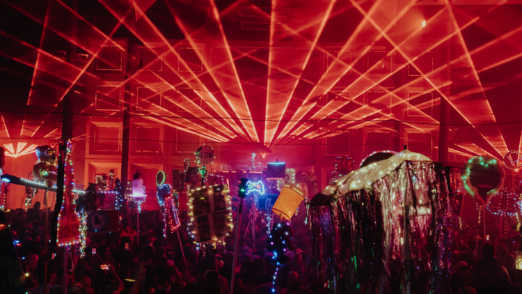 A crowd of doof sticks under red lasers 