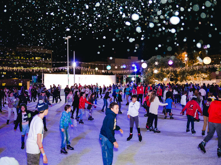 A crowd of people ice skating at Ice at Santa Monica.