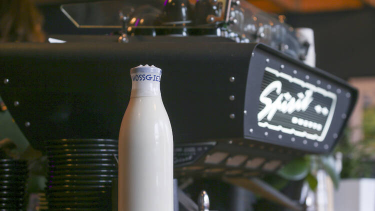 A picture of milk in front of a coffee machine