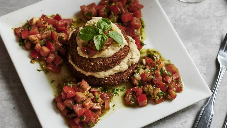 Eggplant Napolean on a white dish on a marble table