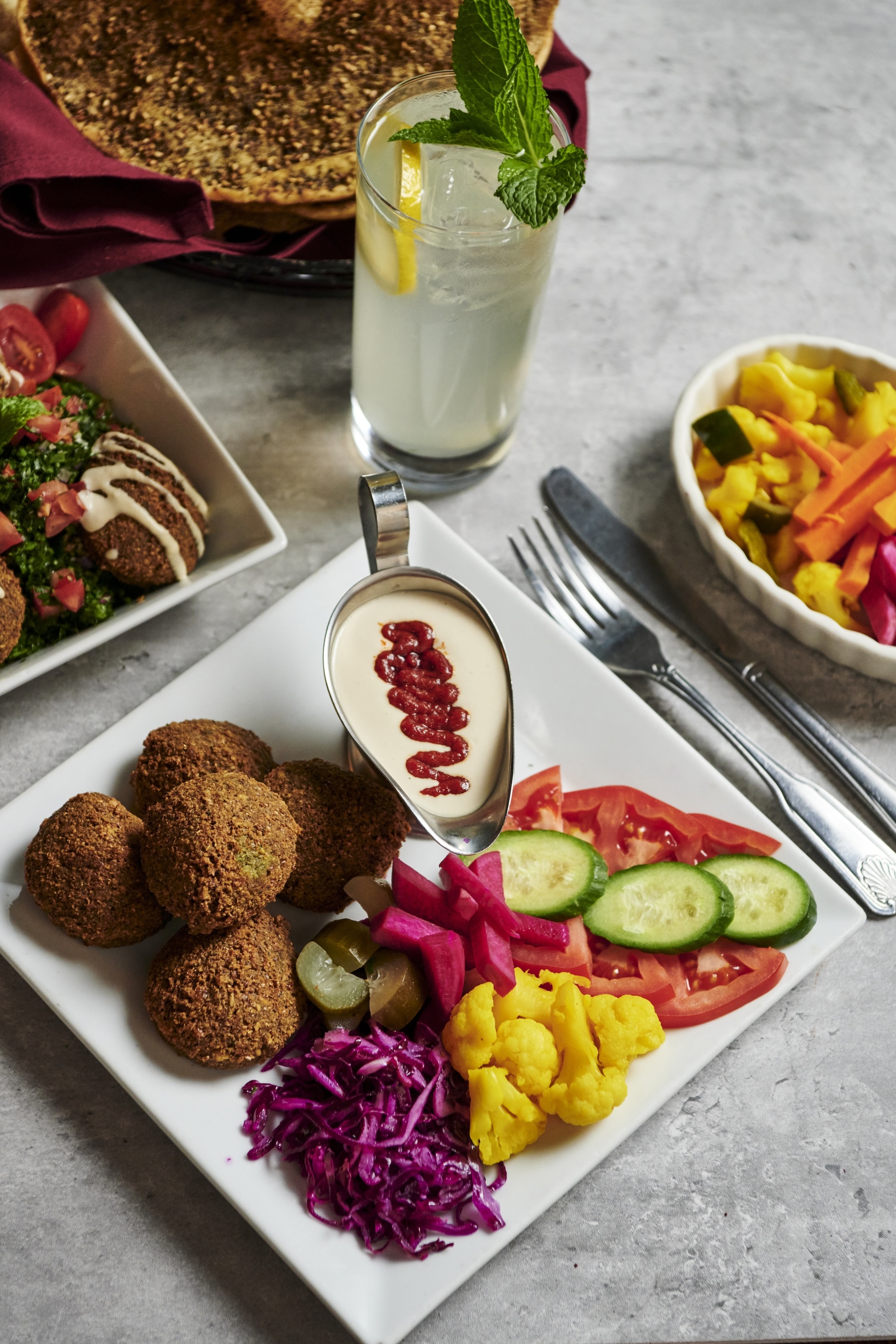 A plate of falafel, vegetables and hummus