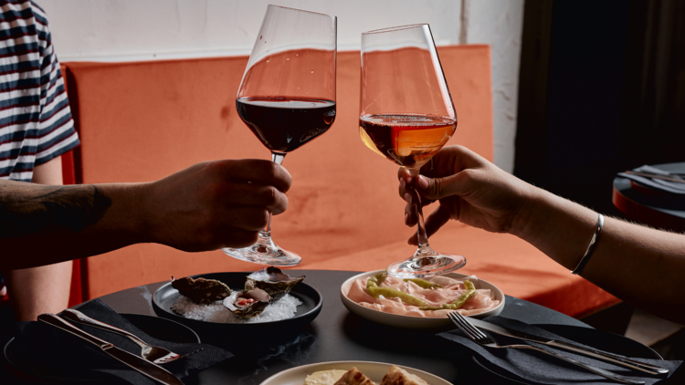 Pair of guests clinking wine glasses at Marama Wine Bar.