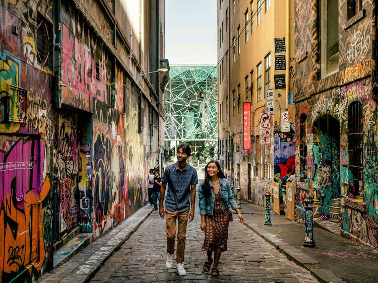 Two people walking down Hosier Lane.