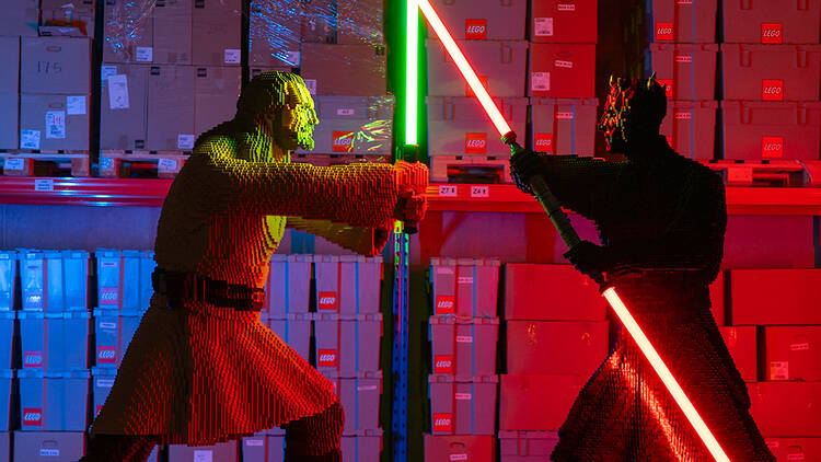 Two Star Wars characters having a light saber fight. 