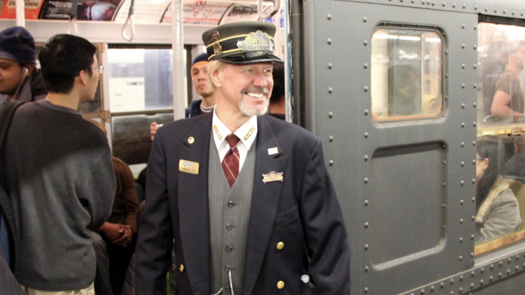 train conductor in front of vintage car