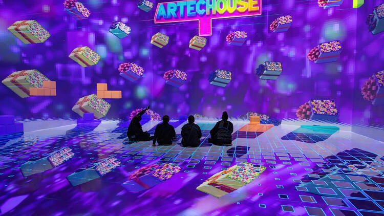 People sit on the floor inside ARTECHOUSE.