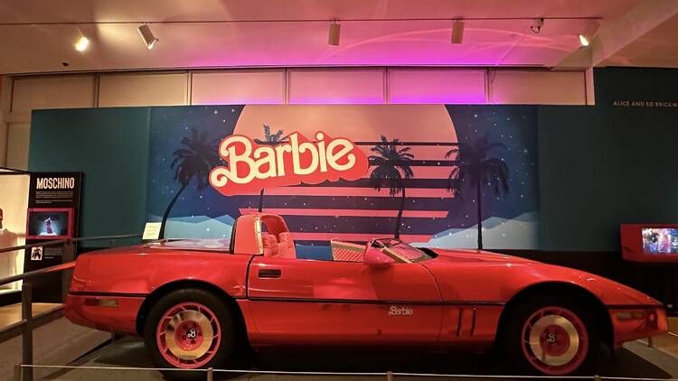 The Barbie car, a pink sports car, at a museum exhibit.