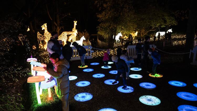 Kids play on lit-up stepping stones.