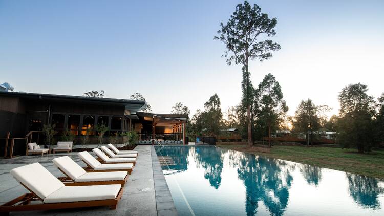 Pool with lounge chairs in bushland