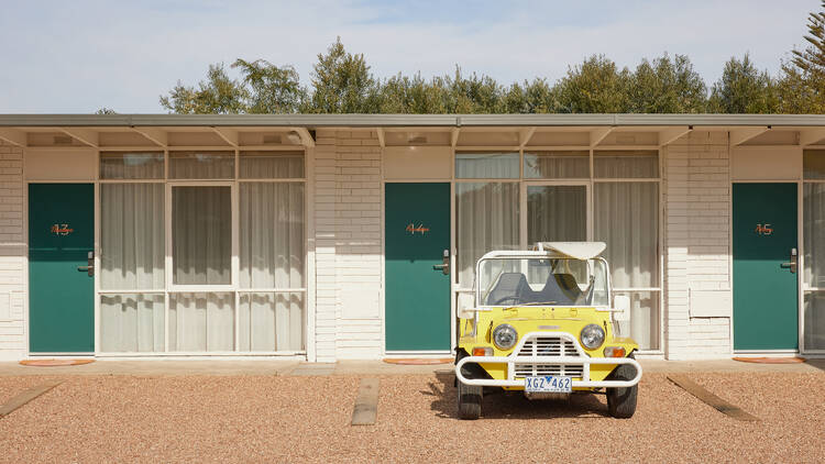 A yellow retro car outside of the Keith Motel.