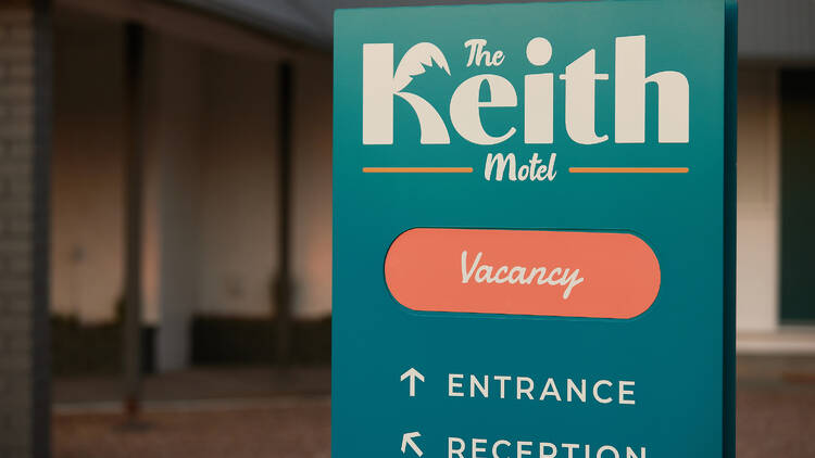 The teal welcome sign for the Keith Motel.