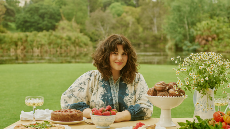 Julia Busuttil Nishimura sitting at a beautifully laid table in the Royal Botanic Gardens. 