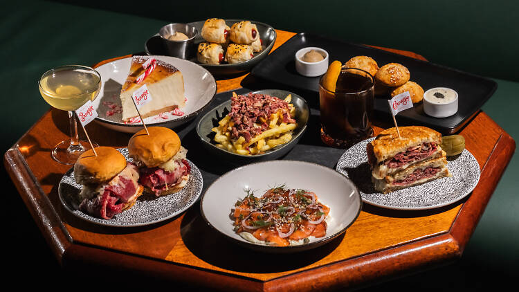 A table full of sliders, sandwiches and cheesecakes