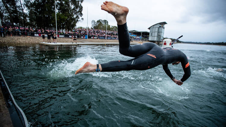 Competitor dives in for the swimming component of IRONMAN Western Sydney.