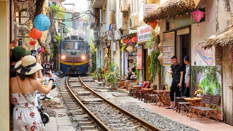 Train passing through a narrow street of the Hanoi Old Quarter, Vietnam