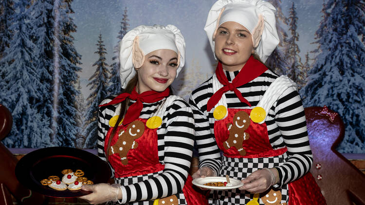 Christmas elves holding plates of treats. 