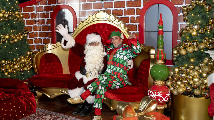 Santa and an elf sitting together. 