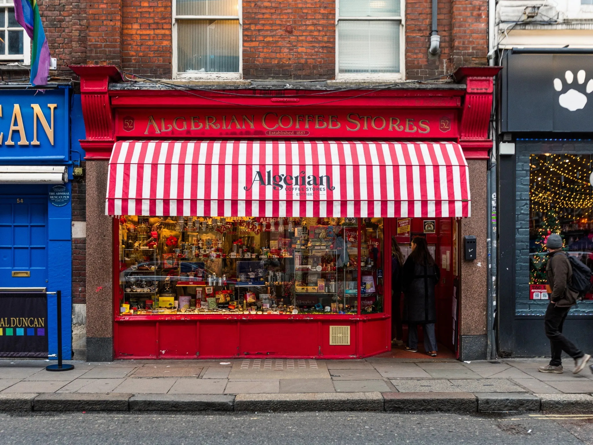 Red and white striped awning in front of red-painted shop Algerian Coffee Stores on Old Compton Street in Soho