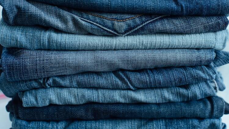 Stack of a stack of old jeans various shades of blue jeans. Denim jeans texture. Denim background texture for design. Canvas denim texture. Blue denim background.