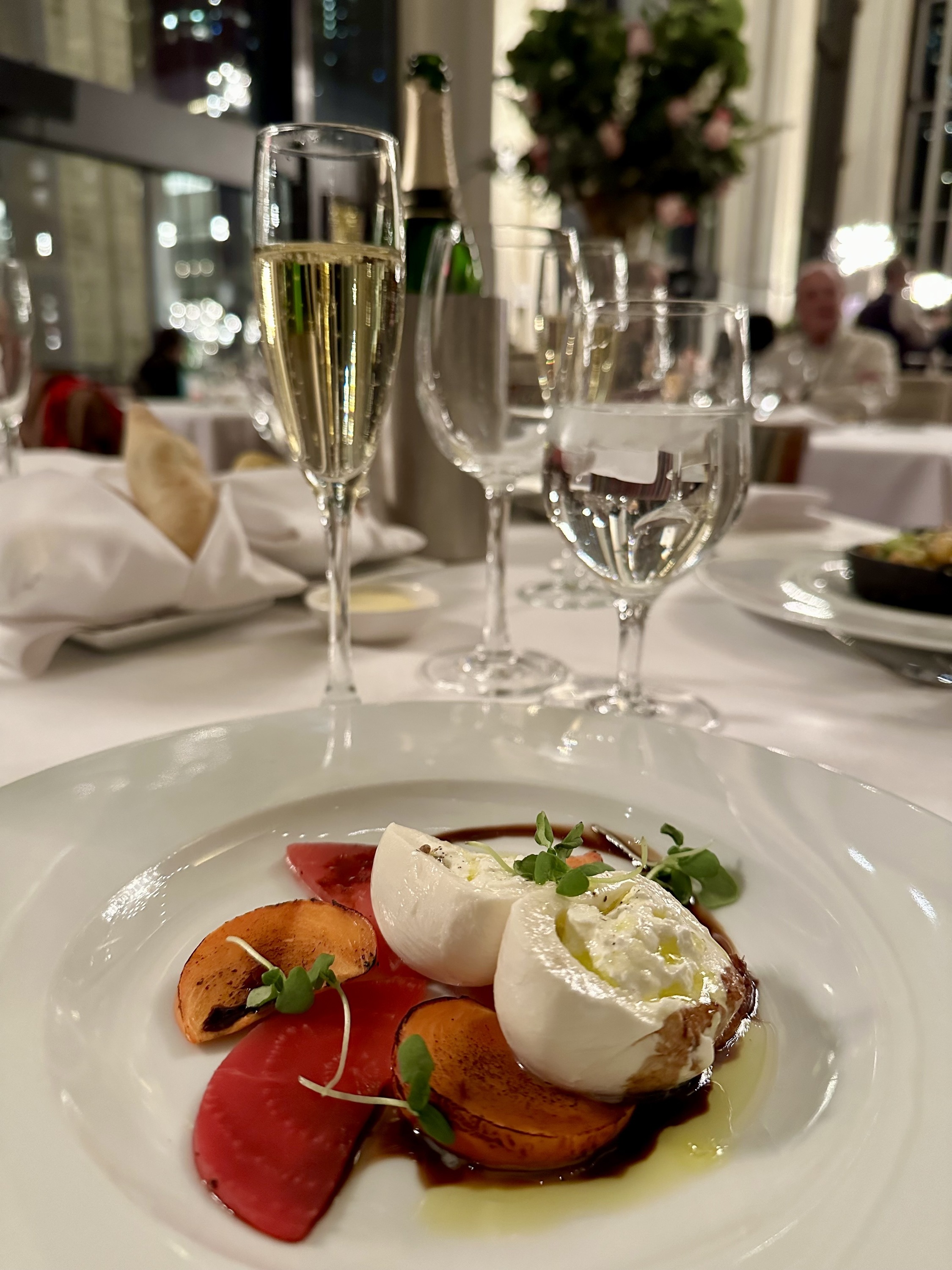 A dish with burrata and wine.