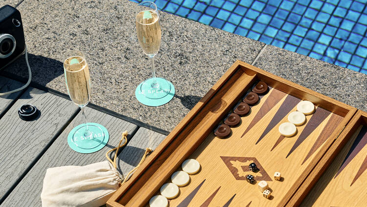 A backgammon set and two glasses of Champagne by the pool.