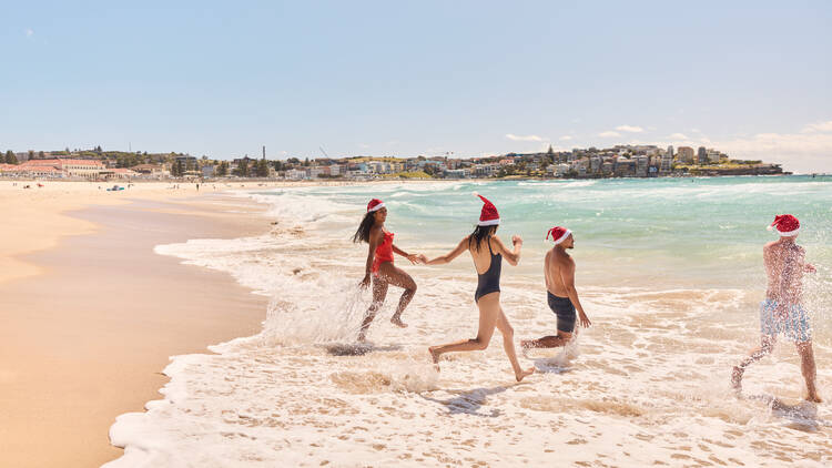 Friends celebrating Christmas and swimming at Bondi Beach in Bondi, Sydney