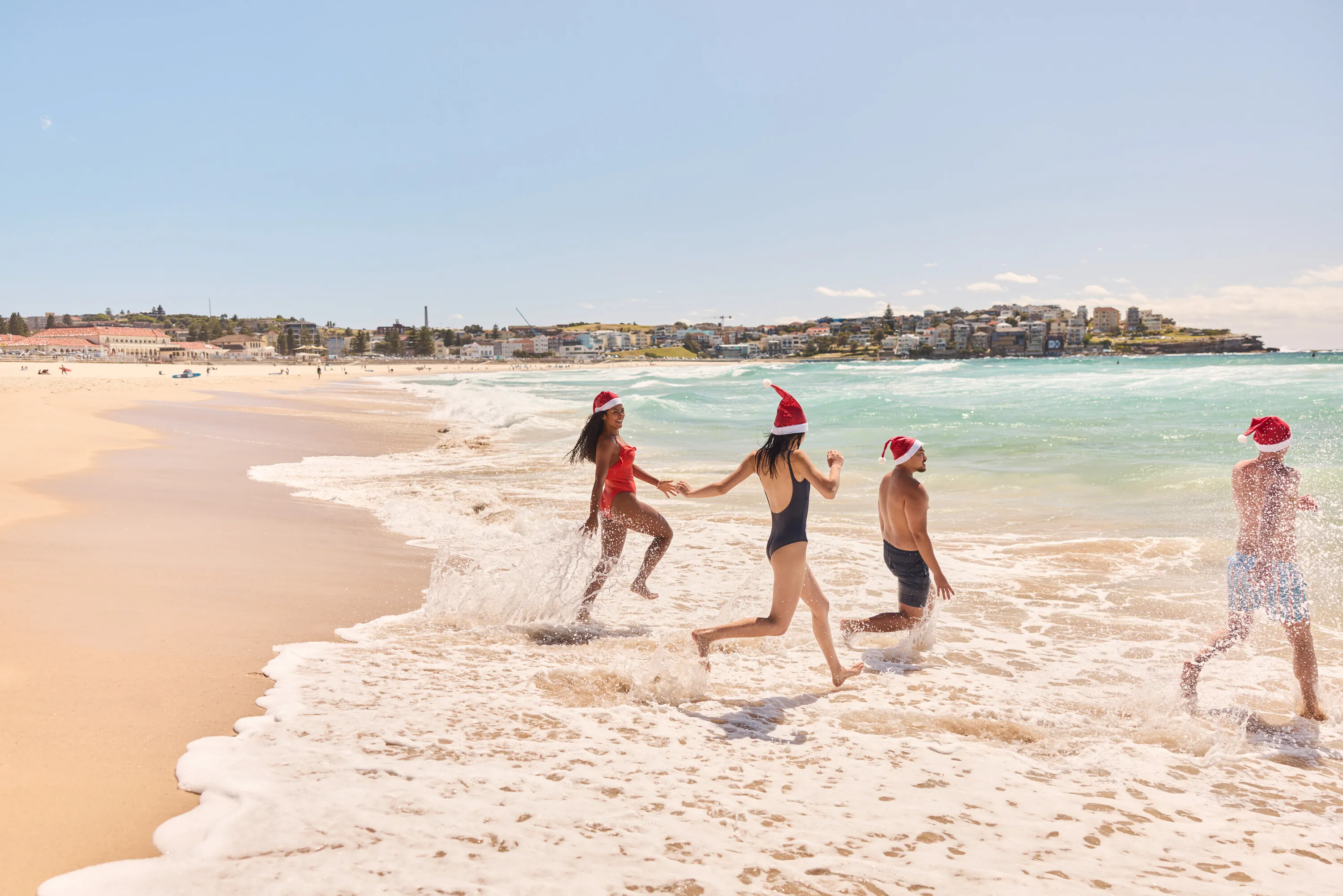 Friends celebrating Christmas and swimming at Bondi Beach in Bondi, Sydney