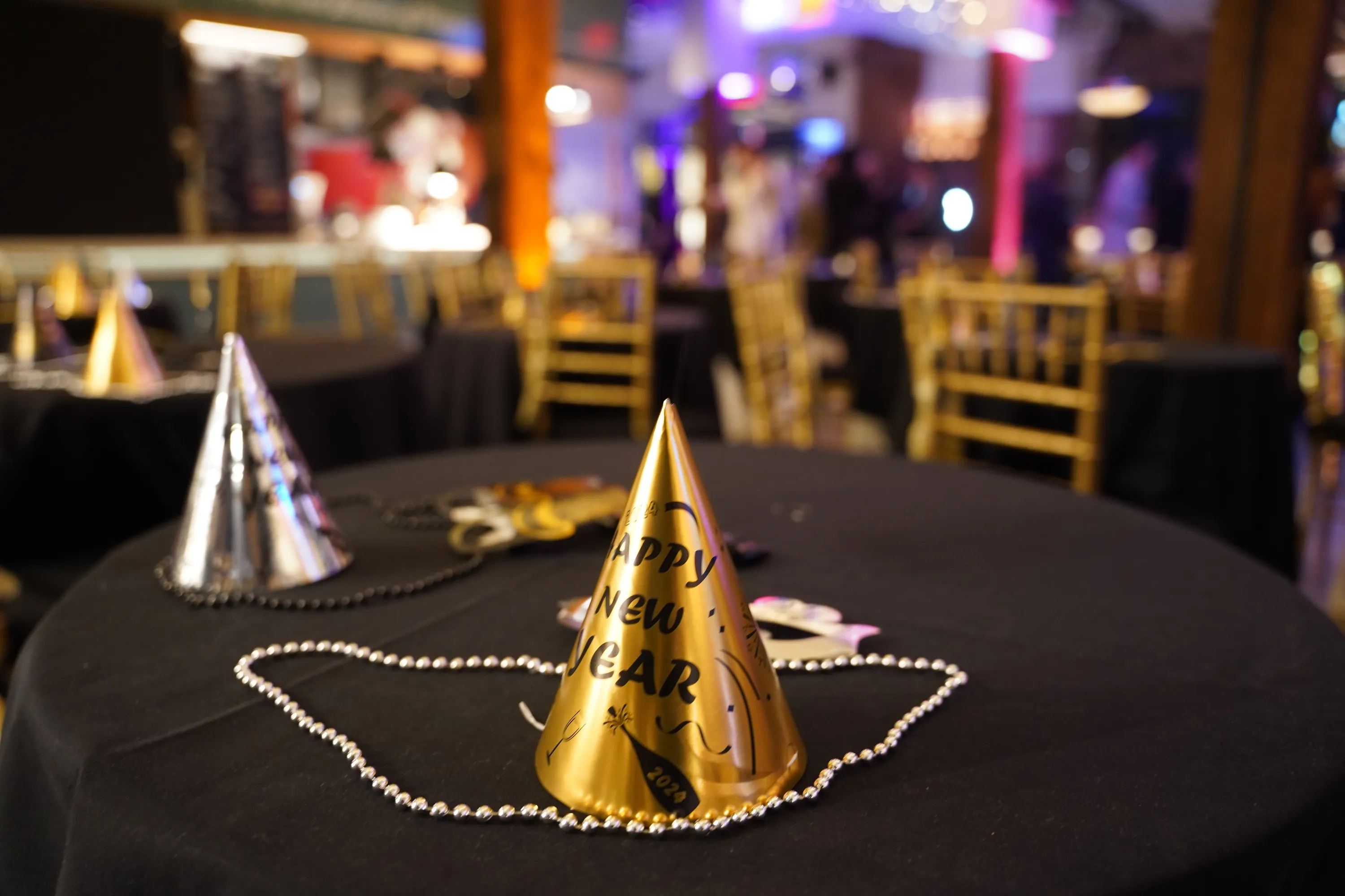 Two party hats on a table that reads 'Happy New Year'