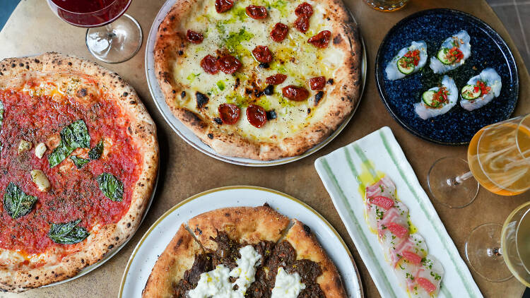 A table full of pizza and beer