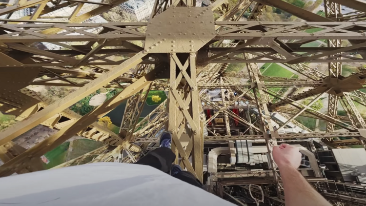 Un spécialiste de parkour réalise un salto sur la structure métallique du deuxième étage de la tour Eiffel, perchée à 130 mètres de hauteur