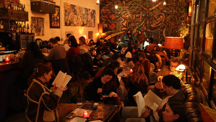 A group of people read in a bar during Reading Rhythms.