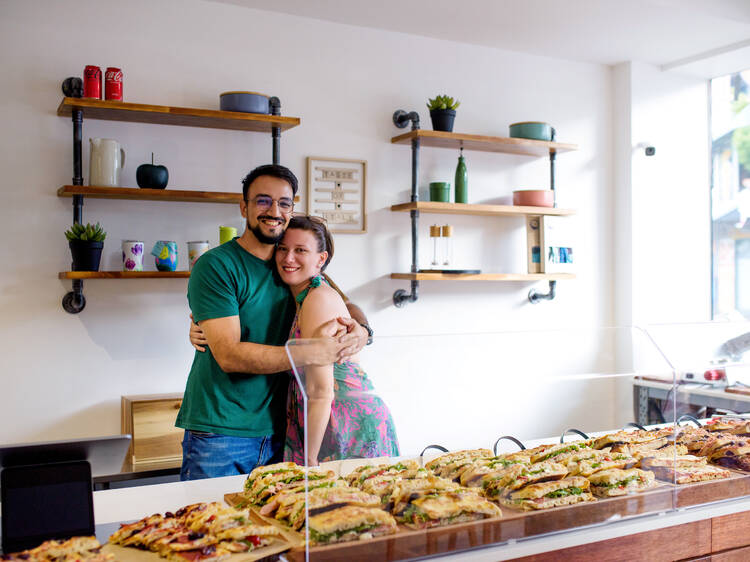 Couple smiling behind cafe counter