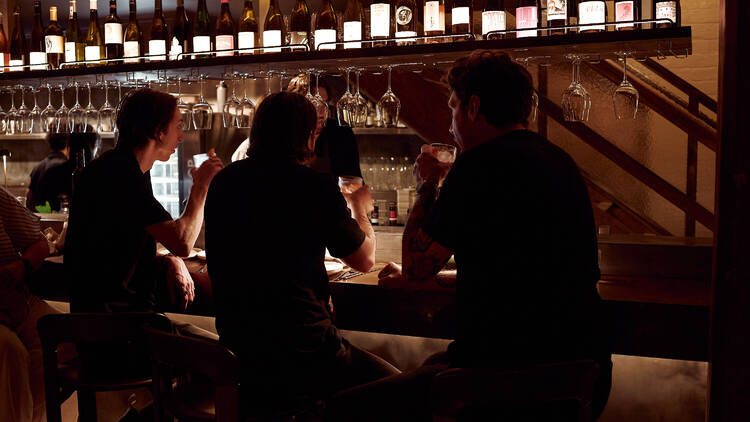 People sitting at the bar at Letra House