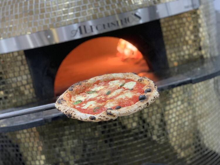 Margherita pizza coming out of oven