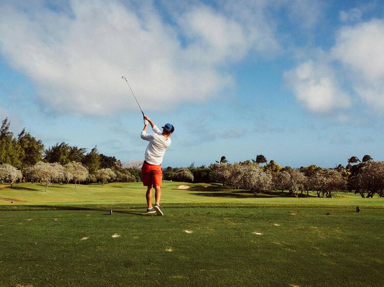 A person hitting a golf ball. 